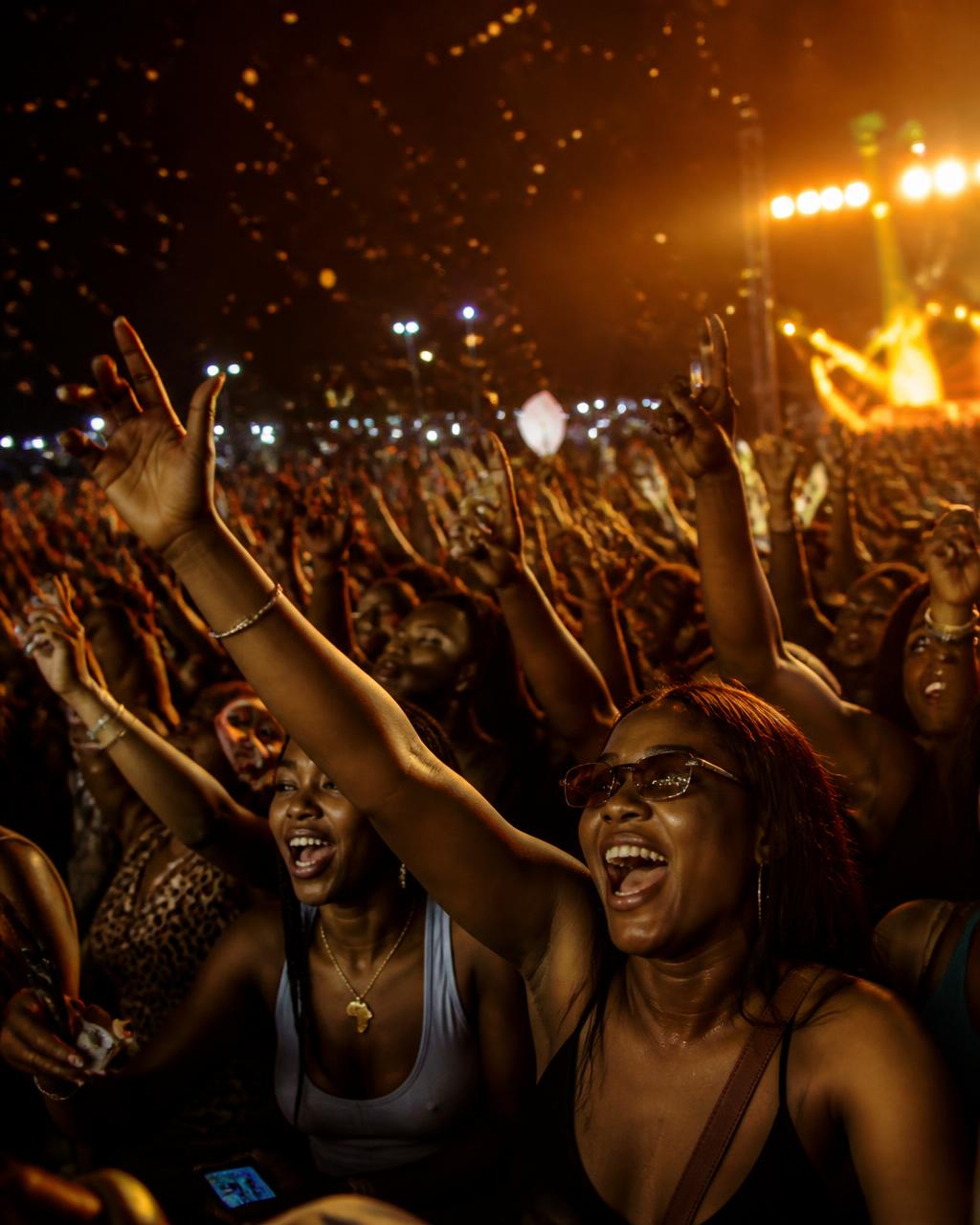 Crowd cheering with hands raised at a Nigerian night concert
